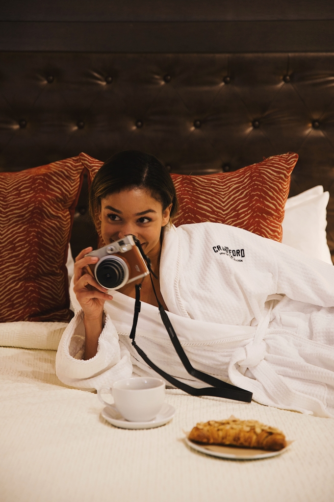 A woman in a Crawford Hotel robe with a camera