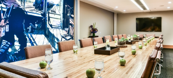 A long conference table with water and apples