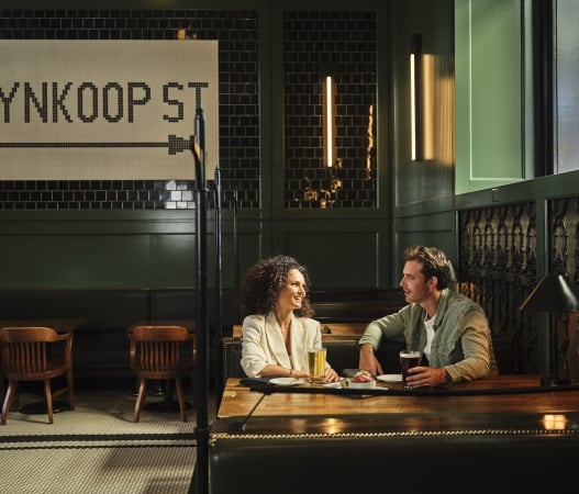 two people talking and enjoying drinks at the terminal bar