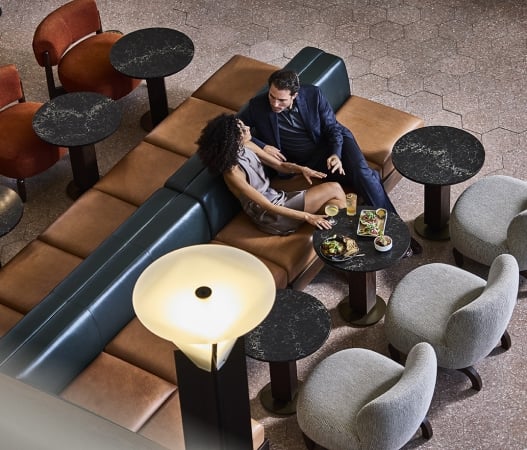 a man and woman talking to each other at the terminal bar