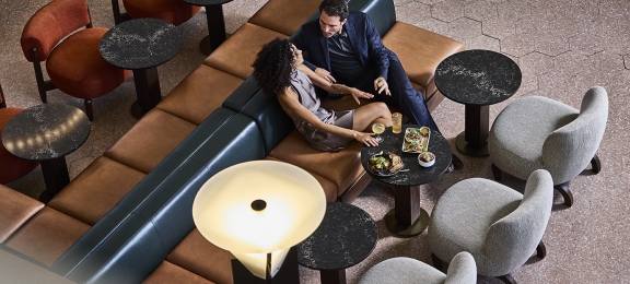 a man and woman talking to each other at the terminal bar