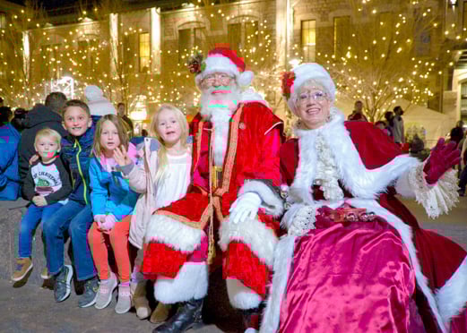Santa and Ms. Claus pose with children in front of Denver Union Station