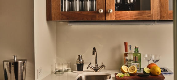a small kitchen area with ingredients needed to prepare cocktails