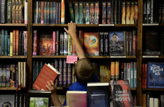 kid grabbing books from a shelve inside denver union station