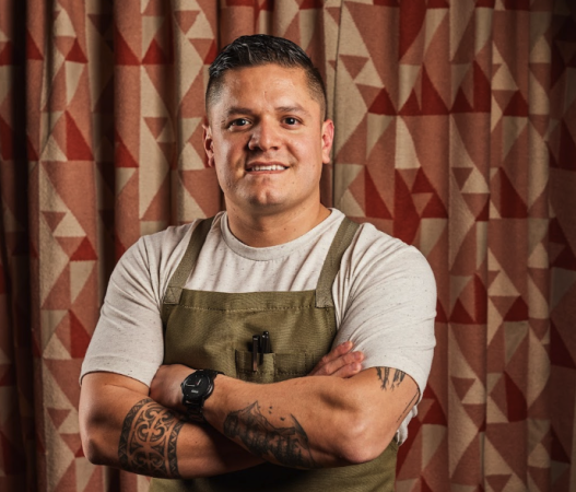 Johnny Curiel standing in front of a curtain