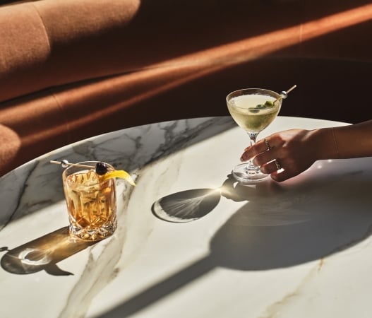 a close up of two cocktails sitting on a table