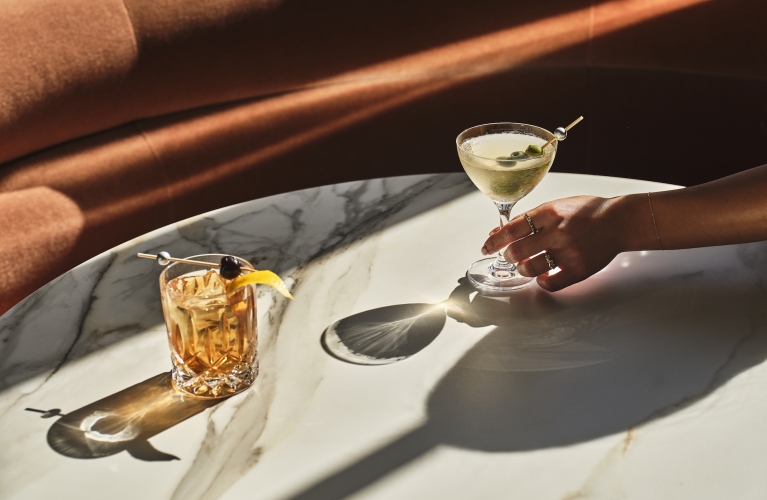 a close up of two cocktails sitting on a table